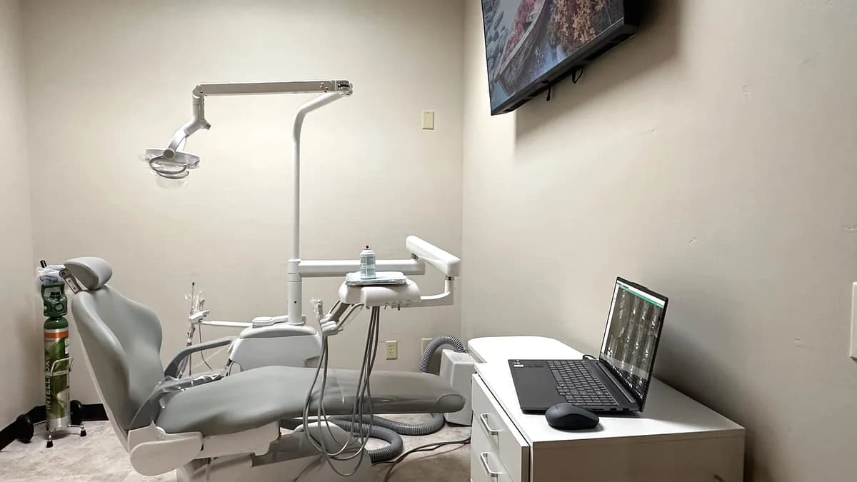 A treatment room with a surgical chair and a monitor for reviewing scans at OAKS Oral Surgery